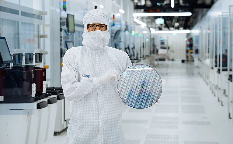 Ein Techniker im Reinraum von Infineon Technologies in Villach, Österreich, hält einen 300 mm Galliumnitrid-Wafer.