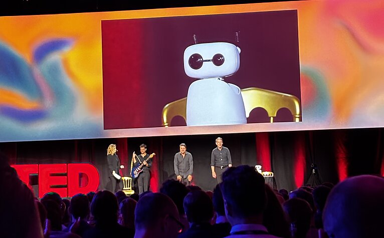 TED AI Vienna 2025: Ein humanoider Roboter wird auf der Bühne der Wiener Hofburg vor internationalem Publikum präsentiert.